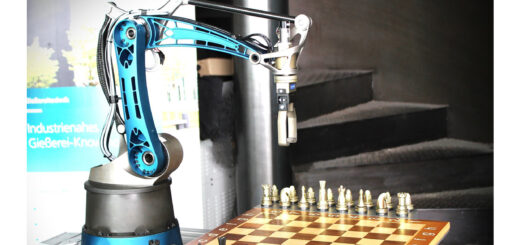 Das Titelbild des Newsletters 08 zeigt den KI gesteuerten Schachroboter. Man sieht ein Schachbrett mit Figuren und darüber einen Roboterarm mit Greifer